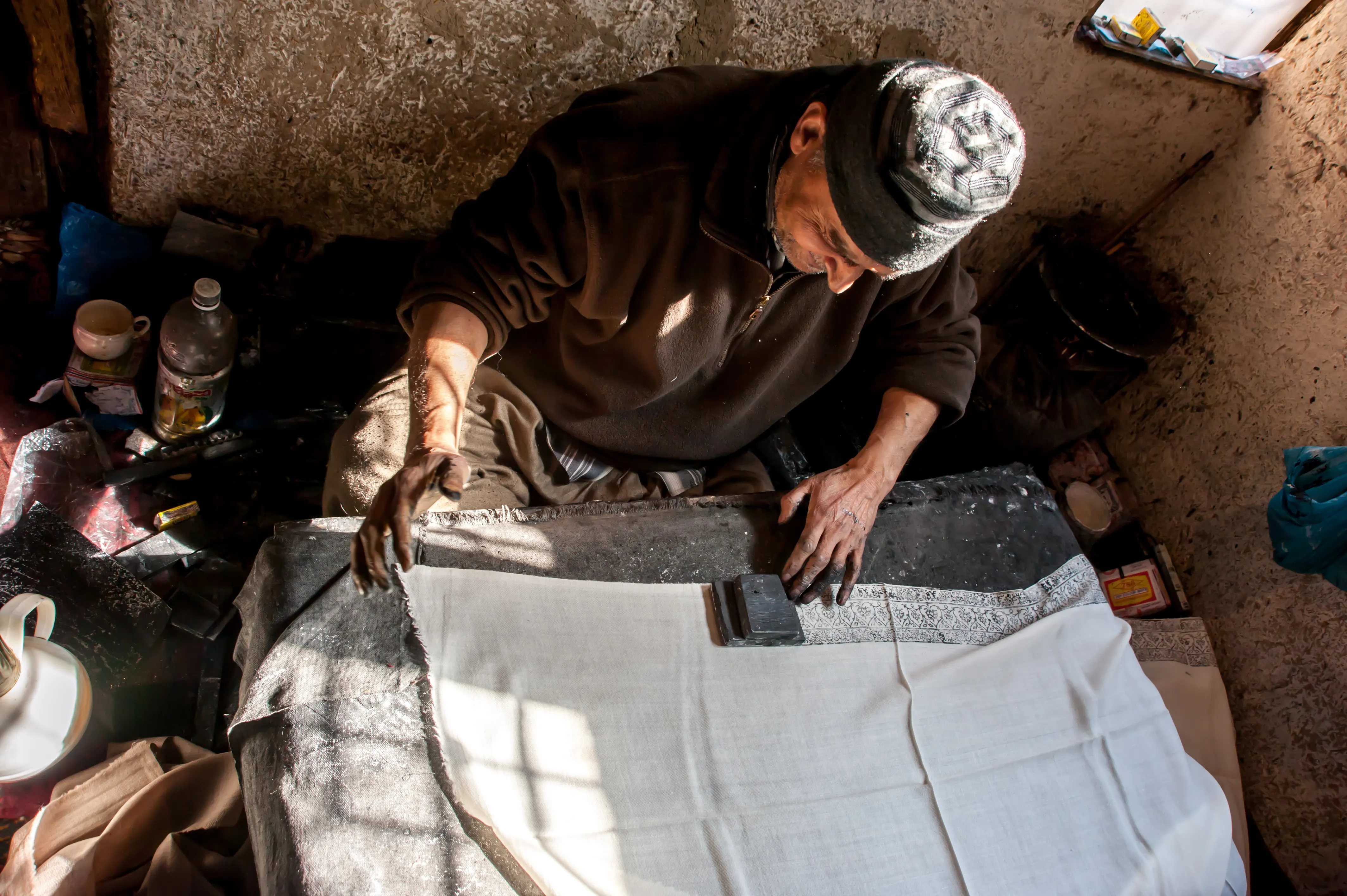 An artisan hand block-printing a pattern onto fabric