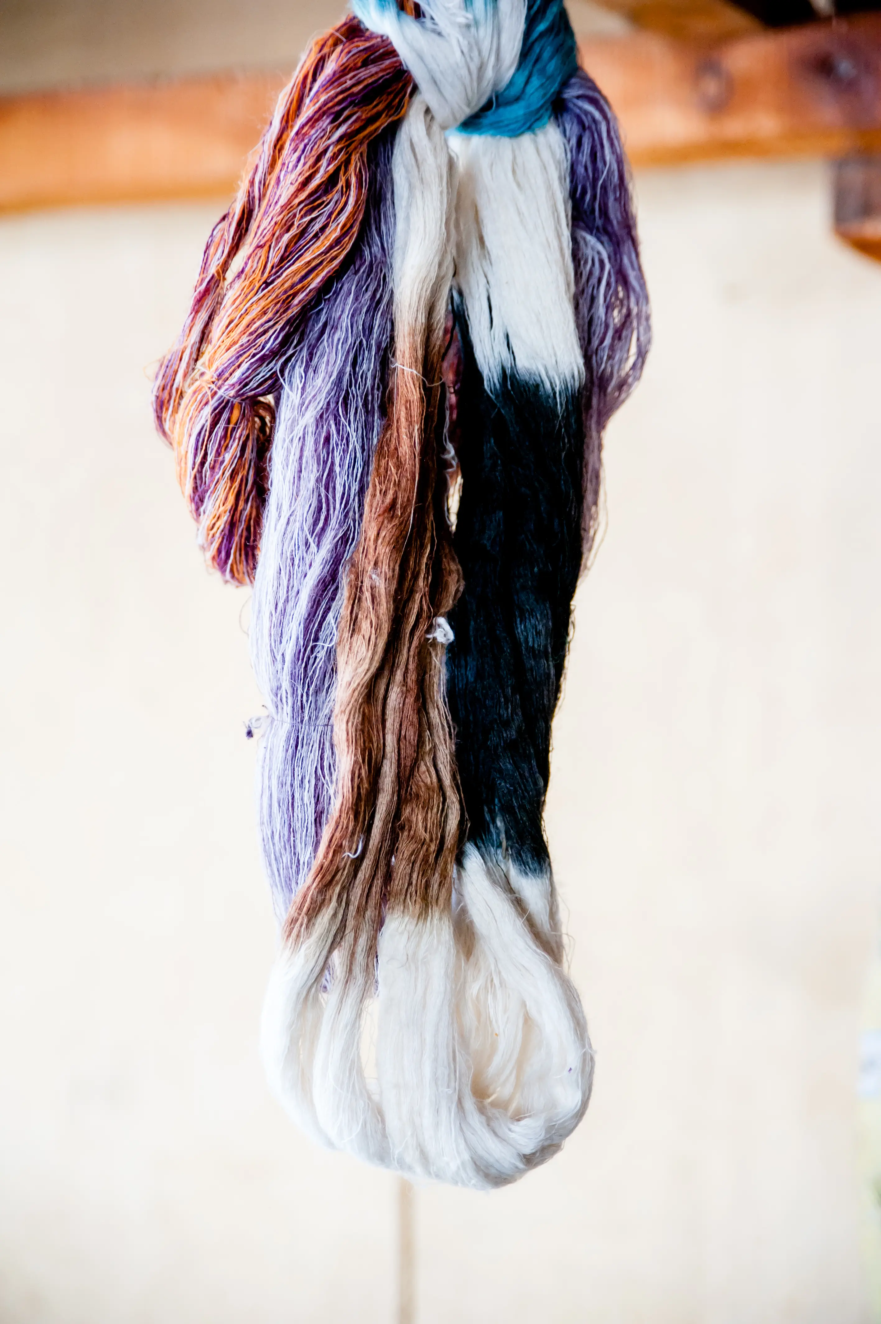 A hank of hand-dyed wool and silk yarn in purple, rust and teal