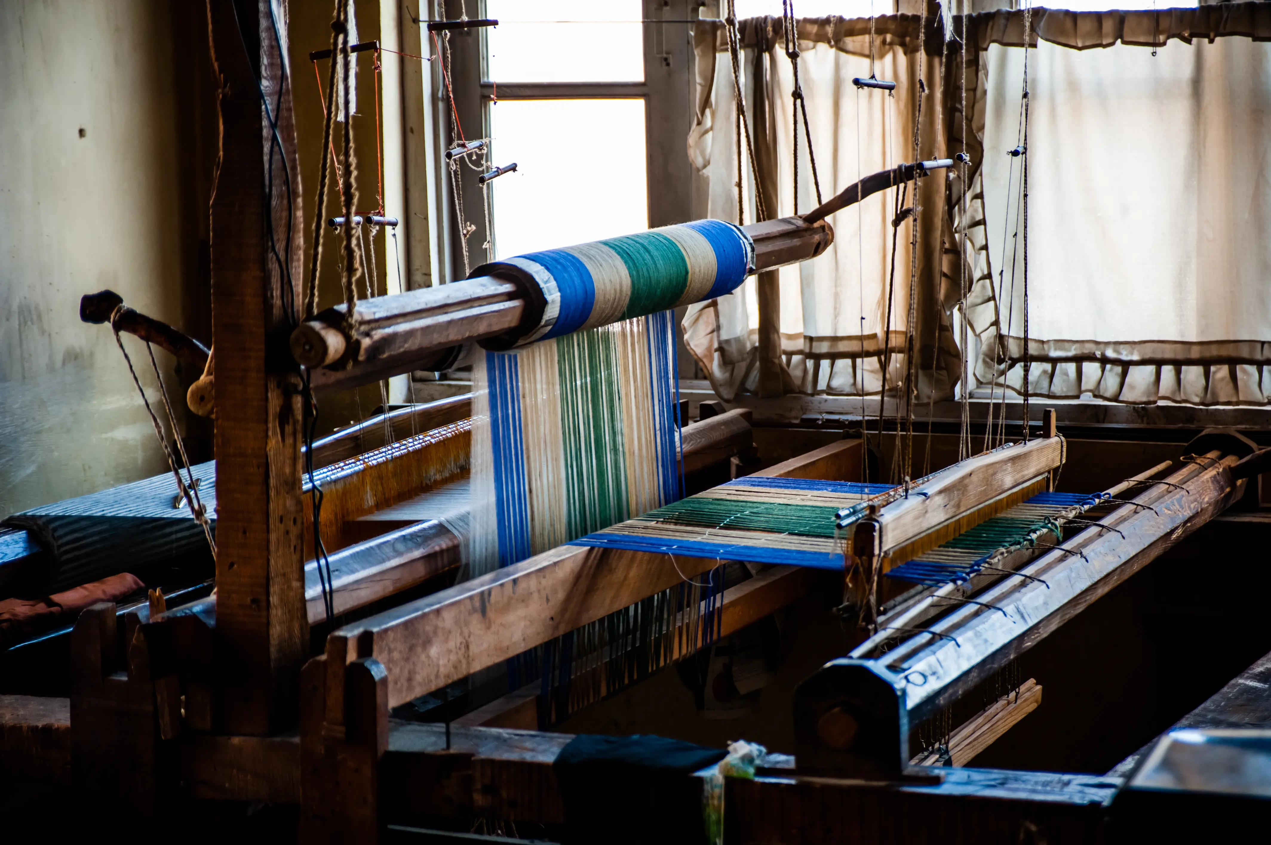 A wide view of a workshop with multiple handlooms